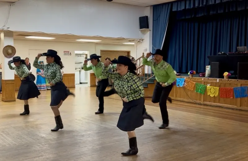 Folklorico dancers performing traditional Norteño dance at a live event